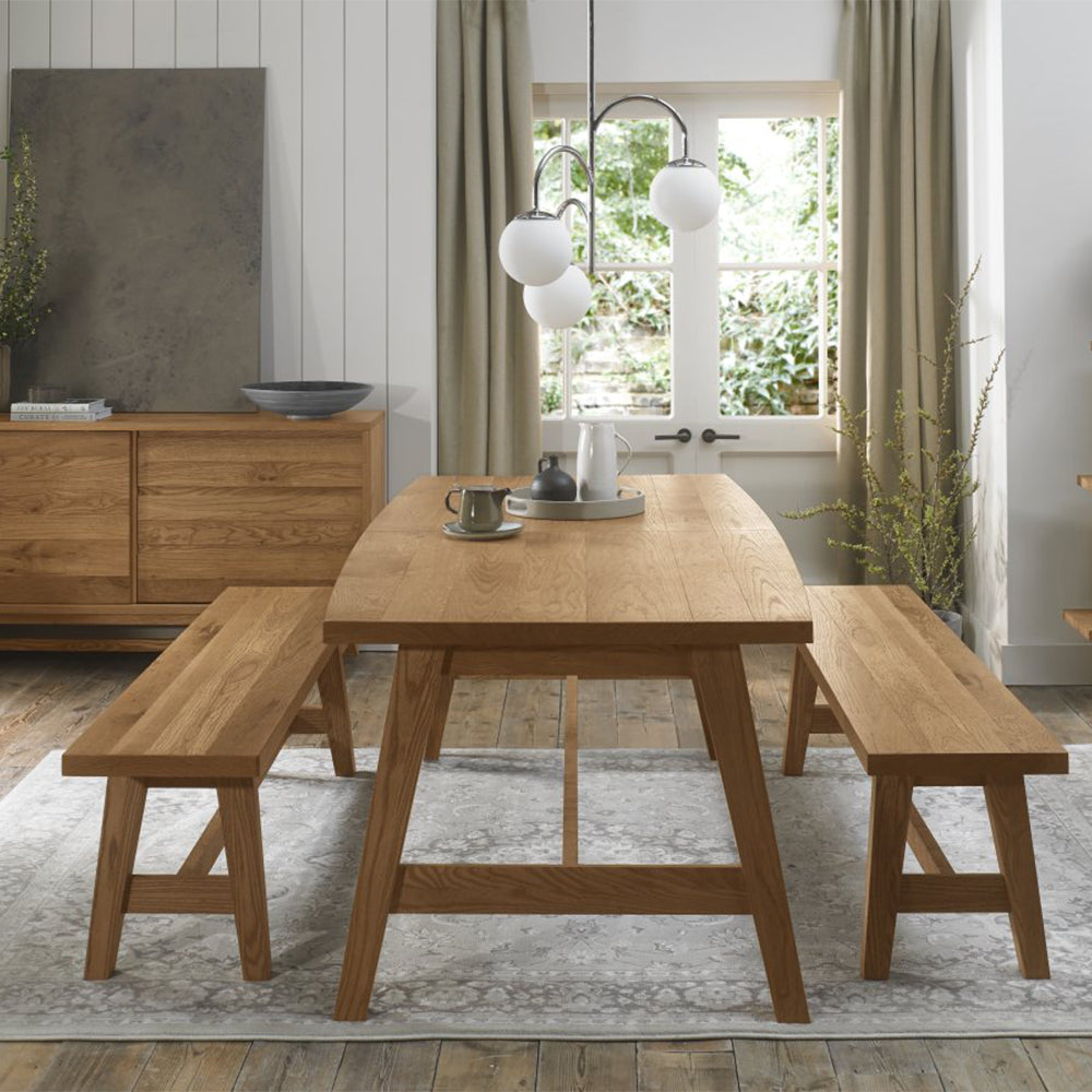 Rustic oak extending dining table with laminated oak tabletops and solid ash legs all in natural finish
