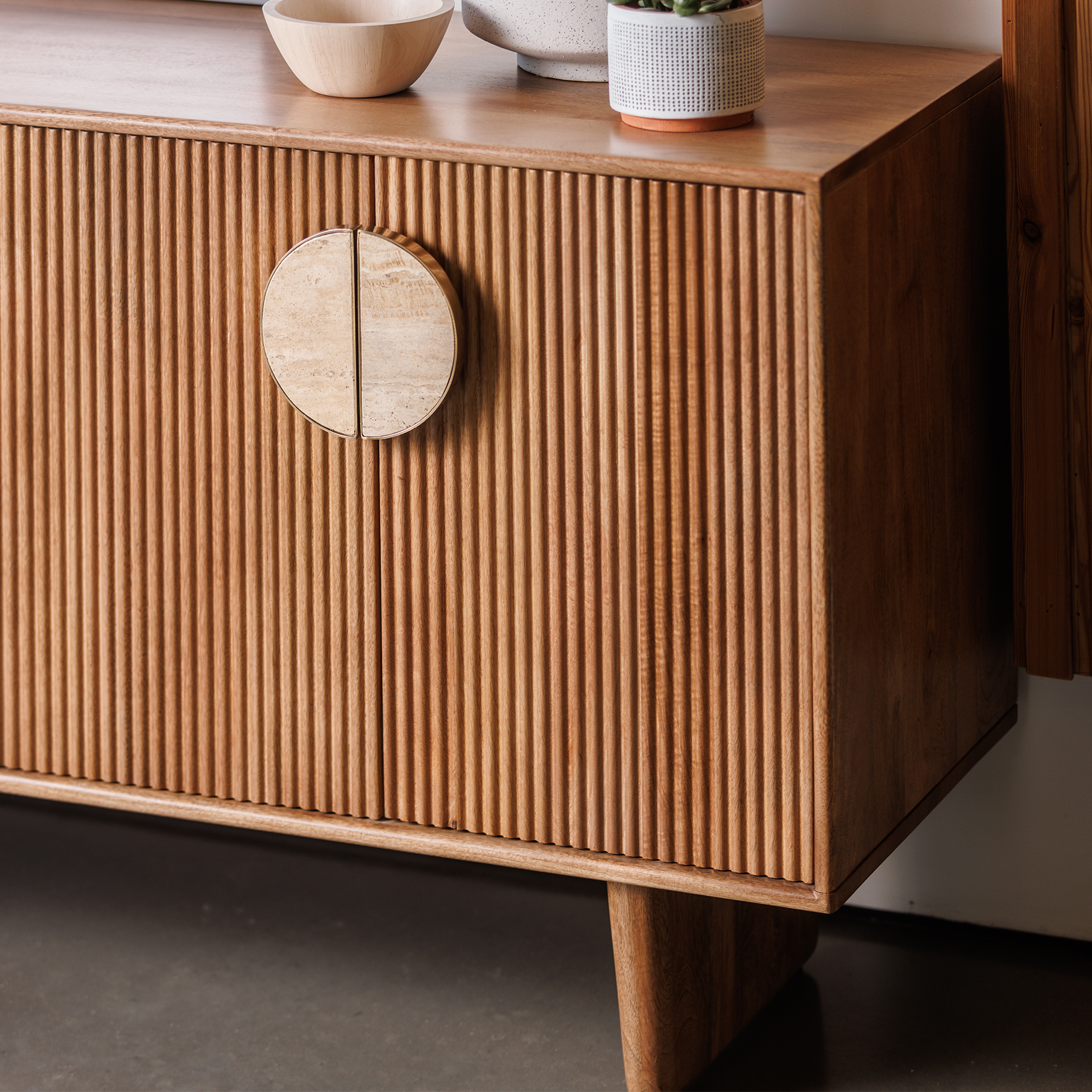 Fluted mango wood wide sideboard with inset handles and travertine stone top
