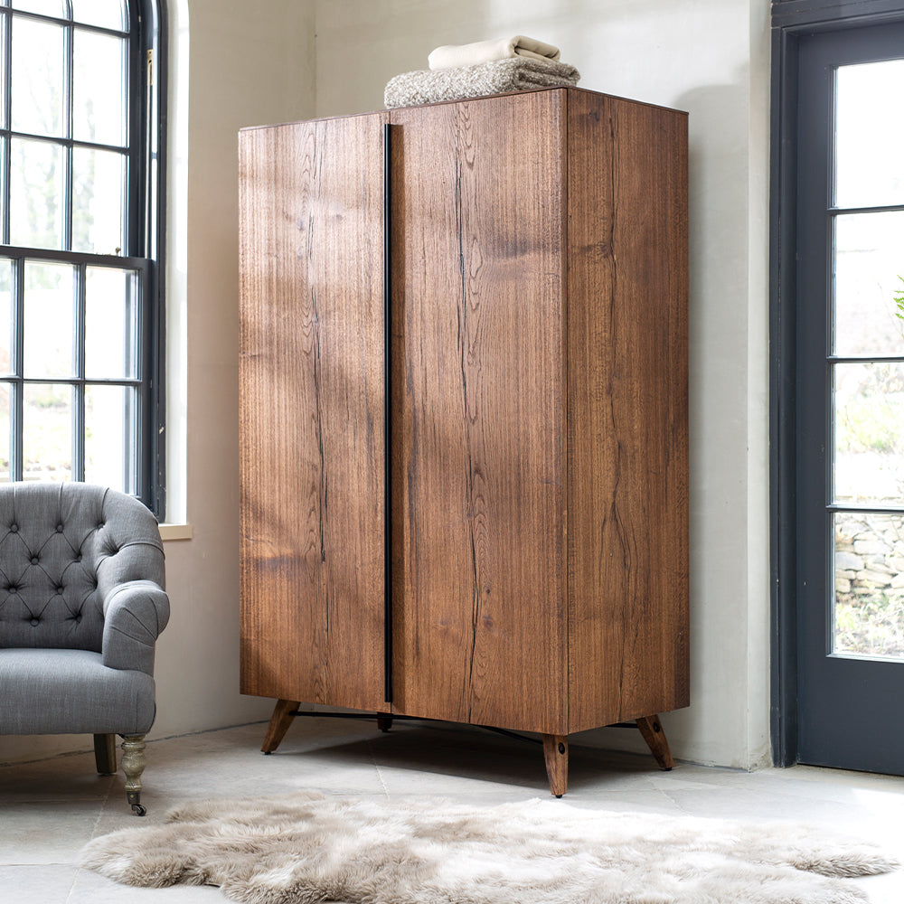 Oak and oak veneer double wardrobe in natural warm finish with wooden legs and black metal bar
