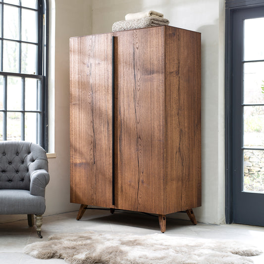 Oak and oak veneer double wardrobe in natural warm finish with wooden legs and black metal bar
