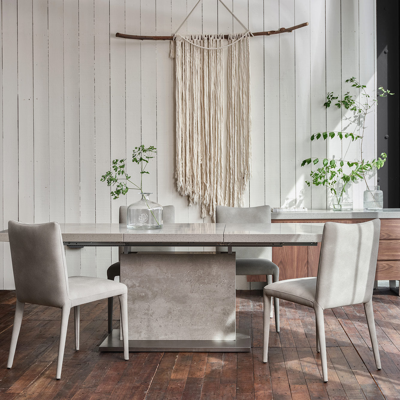 Neutral grey toned stone effect extending dining table set upon matching solid base