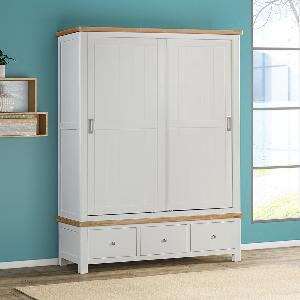 Painted off-white 3 drawer wardrobe, natural wood trim and sleek, silver draw and door handles
