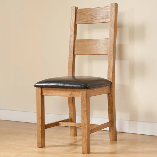 Solid wood dining chair in natural oak finish with dark faux leather seat