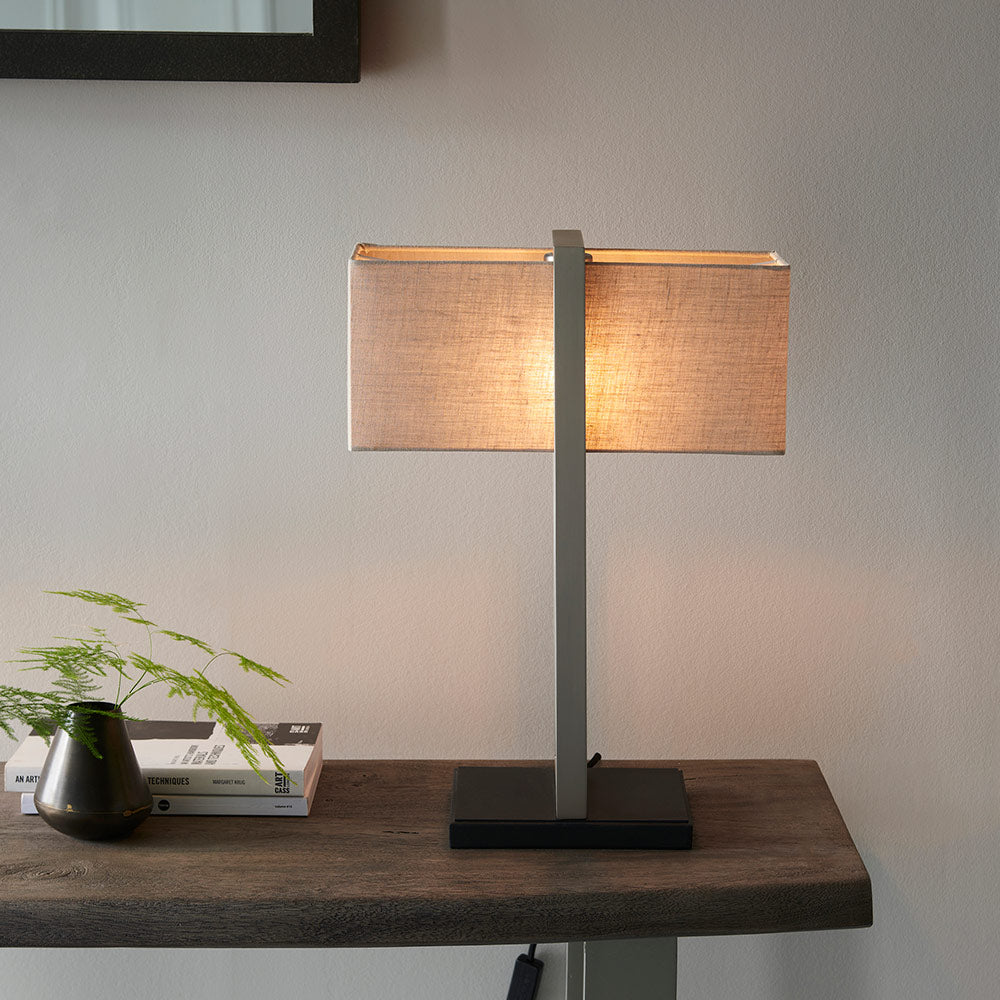 Modern table lamp with matt black base, satin nickel finished frame and linen shade