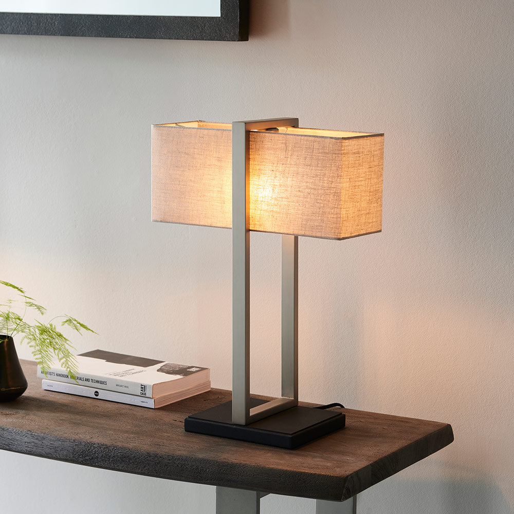 Modern table lamp with matt black base, satin nickel finished frame and linen shade