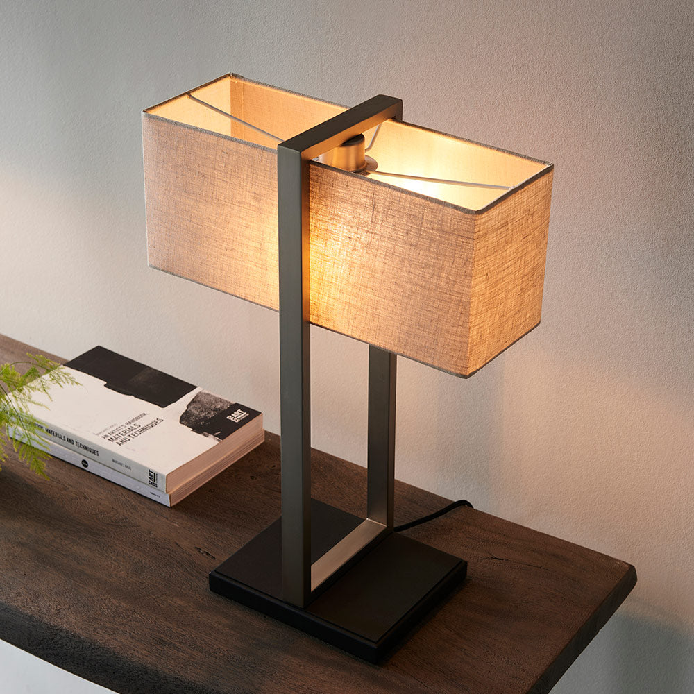 Modern table lamp with matt black base, satin nickel finished frame and linen shade