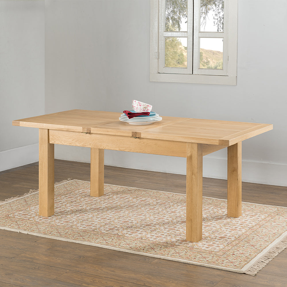 Oak extending dining table in natural finish with four leg base